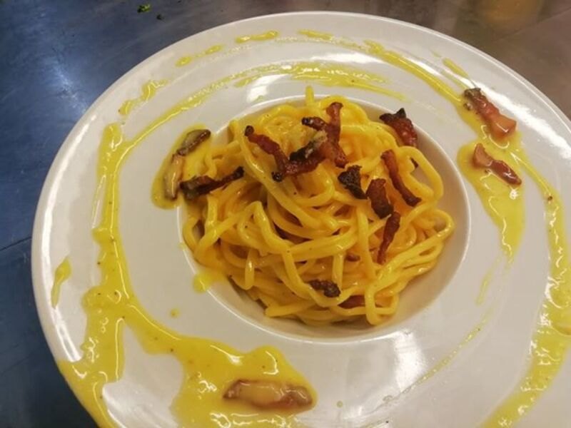 Mezze maniche alla carbonara preparate nella cucina dell'osteria